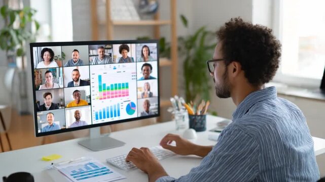 Remote Team Meeting: A focused individual, sits at his desk, engaged in a dynamic video conference, the screen alive with a diverse group, data charts adding context to a digital gathering.  - Powered by Adobe