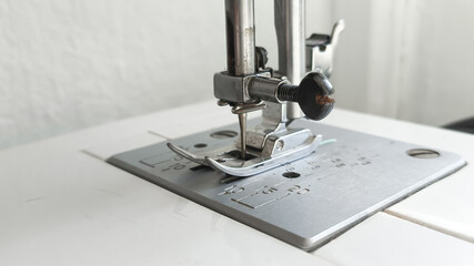 Metal sewing machine foot close-up. Atelier, clothing industry