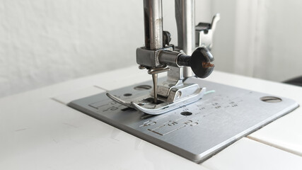 Metal sewing machine foot close-up. Atelier, clothing industry