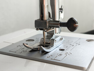 Metal sewing machine foot close-up. Atelier, clothing industry