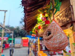 Birds tend to their nest crafted with care, hanging elegantly against a blurred forest backdrop. The peaceful environment reflects natures rhythm and quiet resilience.