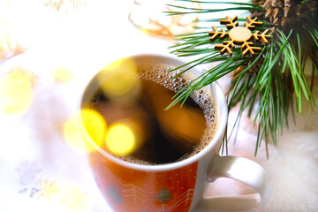 Cup of coffee. Christmas tree and decorations, Cozy home. Soft blur light, golden lens flares. Christmas atmospheric mood. Holiday spirit. Merry Christmas and Happy New Year.