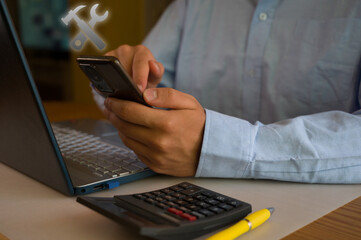 Businessman using smartphone and laptop in office. Man scrolls social media, checks email, manages...