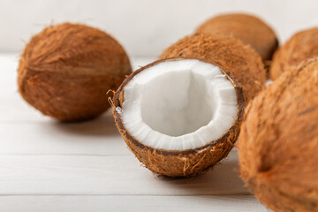 Set of fresh whole and half coconuts and slices on wooden background. Coconut flakes. Vegan. Tropical nut, fruit. Place for text. Copy space.