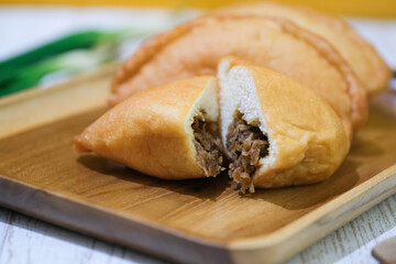Panada. Is a typical culinary specialty of Manado, North Sulawesi, which is soft fried bread stuffed with spicy skipjack tuna pampis. Flatlay