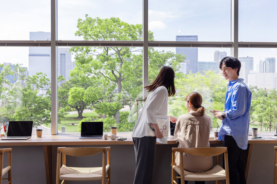 デザイナーズオフィス　新緑　ビル群　青空　窓辺