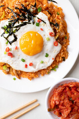 Top view of Korean kimchi fried rice with fried egg, pork, sesame seed, chili, spring onion and seaweed 