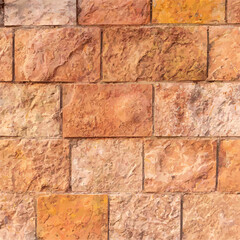 Close-up of a textured brick wall with varying shades of brown and orange
