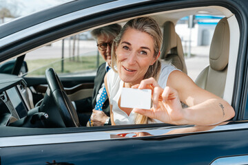 Smiling woman celebrates after passing driving test and receiving her official driver’s license