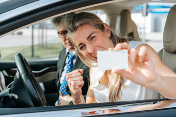 Joyful woman holds driver’s license after passing driving exam and gaining road independence