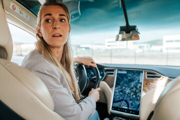 Electric car being reversed by woman checking rear view
