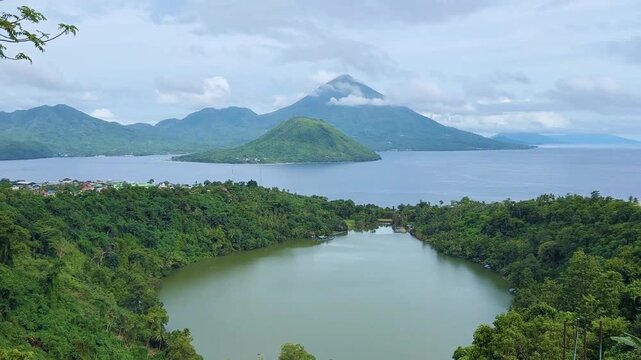 Ngade Lake, Ternate, North Mollucas, Indonesia. Beautiful green lake with two mountains and ocean in the background