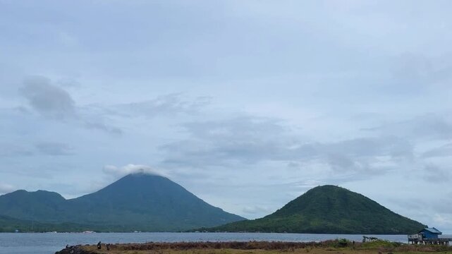 A boat sailing in middle sunny day with beautiful mountain in the background. Tidore Island, North Mollucas, Indonesia
