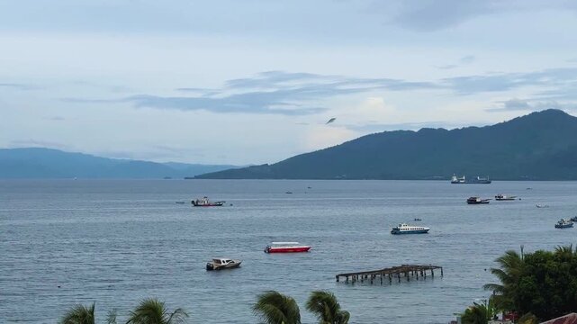 A boat sailing in middle sunny day with beautiful mountain in the background. Tidore Island, North Mollucas, Indonesia