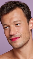 Obraz premium Portrait of a European Man with Glittery Skin and Lipstick Stains on Lips Smiling Against a Lilac Background