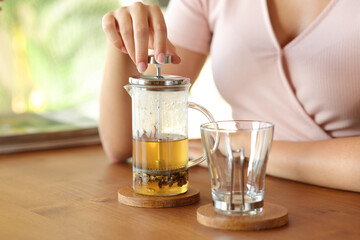 Woman hand preparing tea cup on wooden table