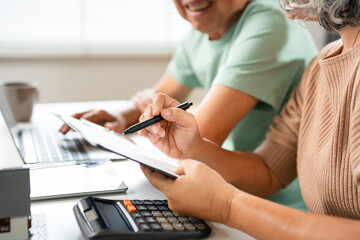 Happy senior couple reading important documents while sitting together at the table at home....
