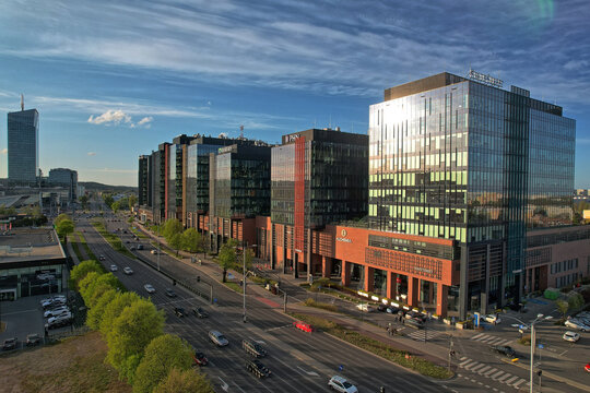 Modern glass office buildings along wide city avenue at sunset