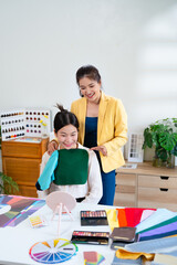 Fabric drapes. Asian stylist conducts a color type procedure for a young woman.personal...