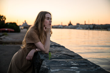 Woman enjoying golden hour on seaside promenade in Helsinki