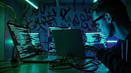 Professional hacker working collaboratively on laptops, coding intensely in dimly lit workspace illuminated by vibrant neon lighting, representing modern technology development environment - Powered by Adobe