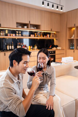 Romantic date at home. happy  man and his girlfriend holding glasses of wine while talking and laughing
