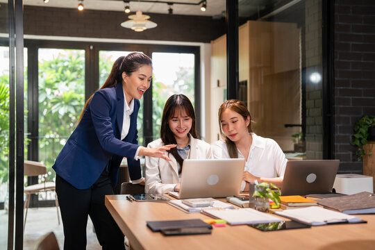 Professional young business woman manager explaining solutions helping young employee at work.