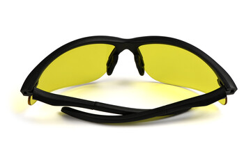 Sports and safety glasses made of black plastic. Fashionable glasses with yellow lenses.