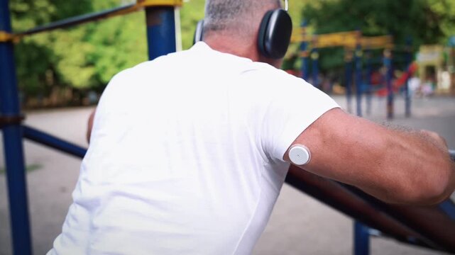 Man with glucose monitoring sensor doing push-ups