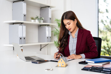 Real estate agent working on contract at desk in office.