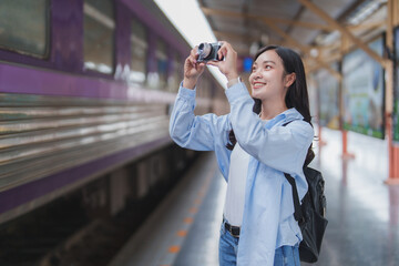 Tourist taking photos of train at railway station