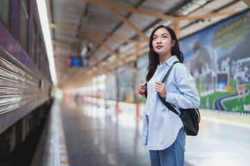 Young woman waiting for train at railway station