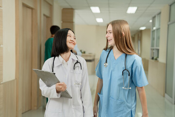 Major Asia doctor woman working and talking with Caucasian woman medical student at hospital	