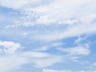 Bright blue sky with soft fluffy clouds on a summer day. Blue sky with clouds. Soft white clouds float in the clear blue sky. Clear blue sky, bright spring, soft sky gradient.