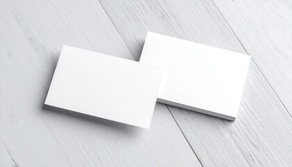 Two blank business cards on a light wood surface