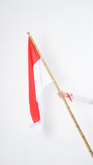 A woman hand with red and white Indonesia flag color attribute holding Indonesia flag to celebrate Indonesia independence day celebration isolated on white background
