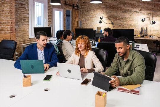 Multi ethnic team collaborating on project in modern office - Powered by Adobe