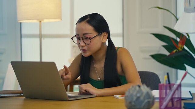 Joyful Korean woman reading university acceptance email, celebrating success