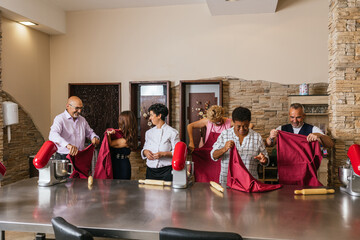 Chefs wearing aprons at cooking course in restaurant kitchen