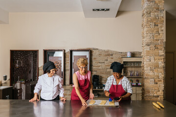 Chefs preparing food in restaurant kitchen during cooking course