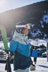 Woman with ski gear prepared for a snow day in snowy parking lot