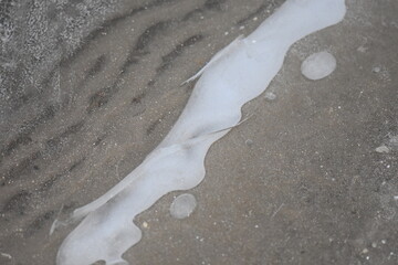 ice and snow on sandy beach in winter, closeup of photo