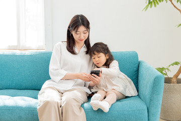 Obraz premium スマートフォンを使う親子 