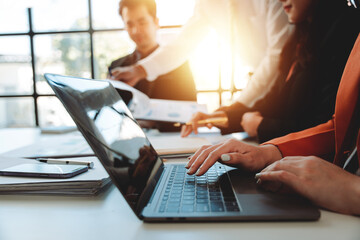 Portrait of a secretary typing information during a meeting in a conference room.