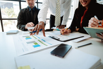 Young colleagues discuss business and analytical price charts using calculators and laptops to calculate financial, tax, accounting, statistics and analytical research ideas.