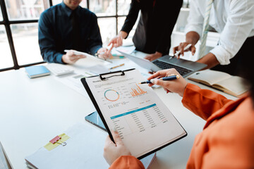 Young colleagues discuss business and analytical price charts using calculators and laptops to calculate financial, tax, accounting, statistics and analytical research ideas.