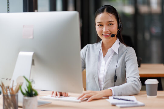 Beautiful asian female operator working laptop and call center agent in the office. Call center customer service. Customer crm and help or support.
