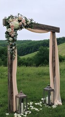 Naklejka premium Rustic wedding arch with floral arrangement, flowing fabric, lanterns, and meadow background