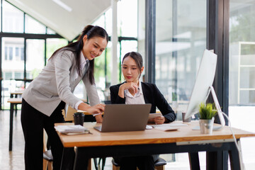 Business asian women Reviewing Documents, Two business meticulously reviewing a stack of documents, highlighting the details and precision in work.	

