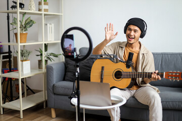 Friendly Musician Waving To His Audience While Playing Guitar And Live Streaming From Home